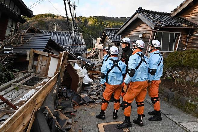 본 소방관들이 2일 이시카와현 와지마시에서 지진으로 무너진 목조 가옥들을 점검하고 있다. [연합뉴스]