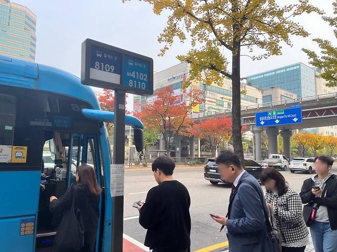 버스정류장에서 예약한 버스를 기다리는 시민들.