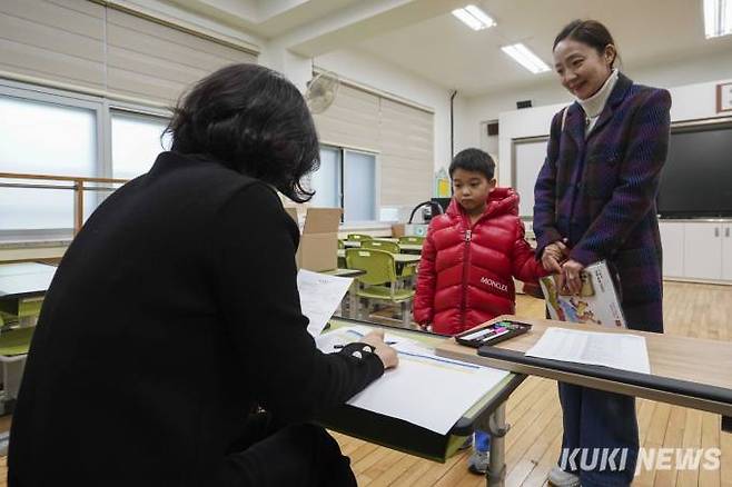 2024학년도 초등학교 신입생 예비소집일인 4일 오후 서울 서초구 원명초등학교에서 학부모와 예비 초등학생이 서류를 작성하고 있다.