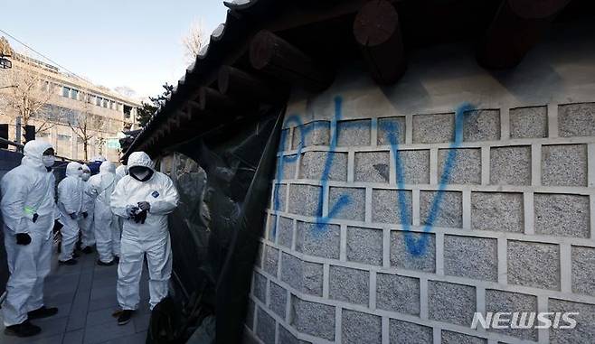 [서울=뉴시스] 배훈식 기자 = 문화재청 작업자들이 17일 오전 서울 종로구 경복궁 서편 담장에 칠해진 낙서 제거 작업을 하고 있다. (공동취재) 2023.12.17. photo@newsis.com