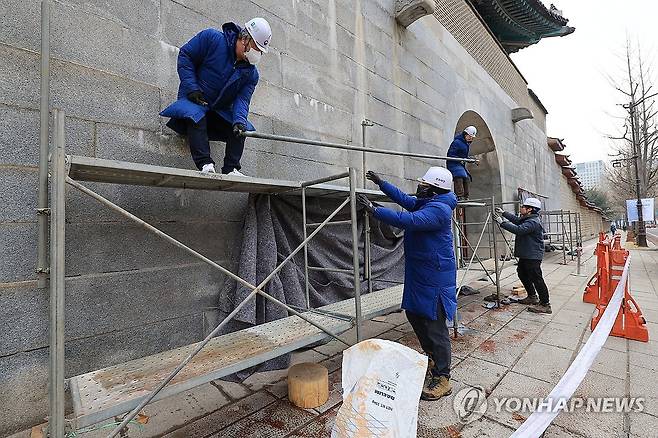 경복궁 담장서 철거되는 가림막 (서울=연합뉴스) 신현우 기자 = 4일 오전 서울 종로구 경복궁 영추문에서 문화재청 관계자들이 가림막을 철거하고 있다. 이날 문화재청은 낙서 제거 작업을 마친 경복궁 담장을 공개한다. 2024.1.4 nowwego@yna.co.kr