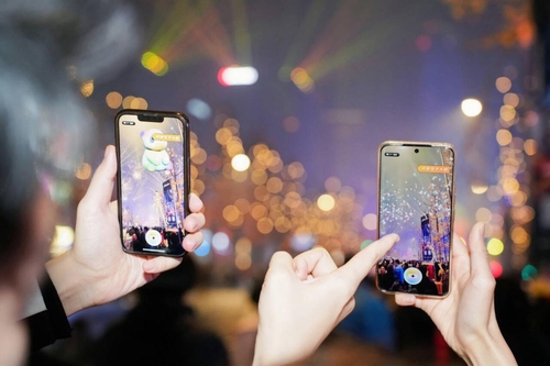 Tourists amazed by the AR street view of Jiaozi Avenue using their mobile phones