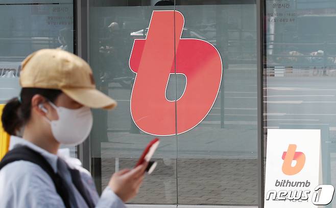 업비트와 빗썸·코인원·코빗 간 가상자산 전송이 한 달 만에 재개된 가운데 26일 서울 강남구 빗썸 라이브센터 앞으로 시민들이 지나가고 있다.. 2022.4.26/뉴스1 ⓒ News1 박지혜 기자
