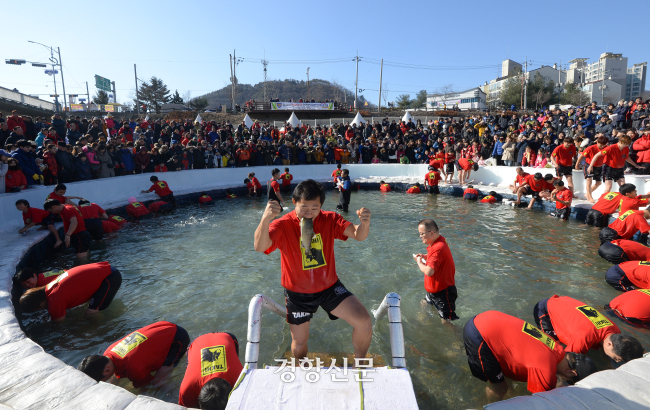 2016년 1월 10일 강원 화천군 화천천에서 열린 화천산천어축제에서 한 관광객이 ‘산천어맨손잡기’에 참여해 손으로 잡은 물고기를 입에 물고 있다. 경향신문 자료사진.