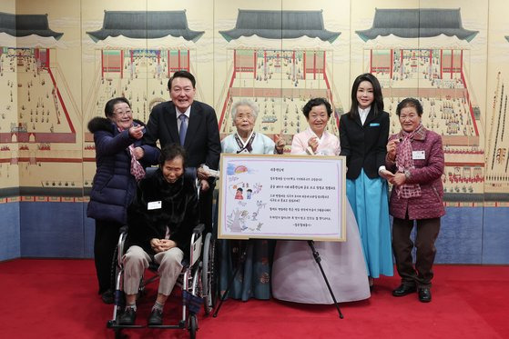 윤석열 대통령과 김건희 여사가 지난해 1월 12일 오후 용산 대통령실에서 칠곡할매글꼴의 주인공 할머니들을 초청해 함께 기념 촬영하고 있다.   칠곡할매글꼴은 경북 칠곡군이 어르신 대상으로 운영하는 성인문예교실에서 한글을 깨친 할머니들의 글씨체로 윤 대통령 부부는 새해 연하장을 할머니의 서체로 제작했다. 뉴스1