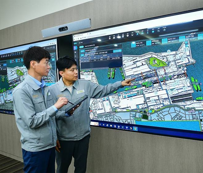 HD현대중공업 직원들이 디지털 트윈을 활용한 가상 조선소 '트윈포스(TWIN FOS)'를 통해 조선소 공정 상황을 실시간으로 살펴보고 있다. HD한국조선해양 제공