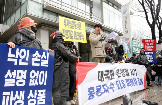 Investors in a troubled Hong Kong-linked derivative product hold a rally in front of the Financial Supervisory Service office in western Seoul on Dec. 15 ahead of the products' imminent maturity. [YONHAP]