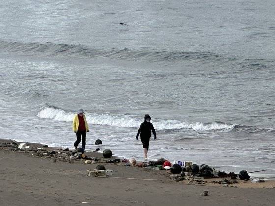8일 오전 8시 제주시 이호해수욕장을 찾은 시민들이 백사장 해양쓰레기를 피해 어싱(맨발걷기 운동)을 하고 있다. 최충일 기자