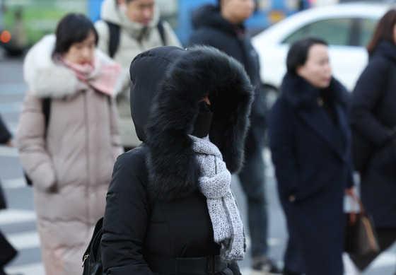 Bundled-up residents walk in the streets of Jongno District in downtown Seoul as a cold wave swept through the capital on Monday morning. Morning lows in the capital fell to as low as minus 10 degrees Celsius (14 degrees Fahrenheit). [YONHAP]