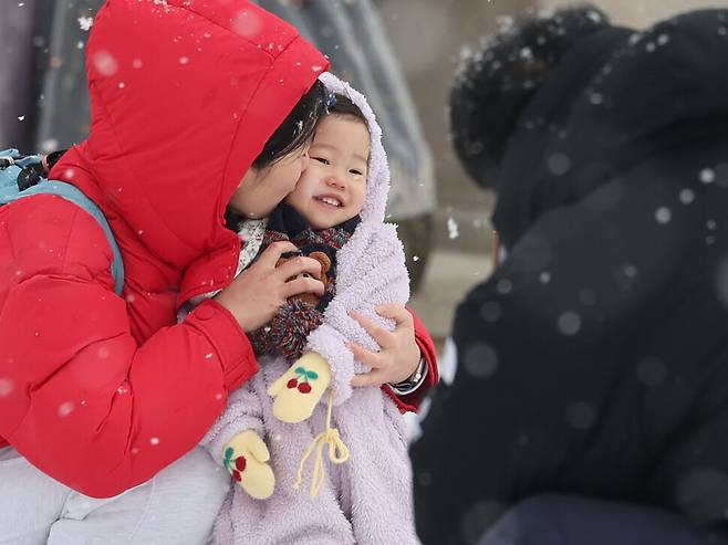 서울에 대설주의보가 발효된 9일 오전 서울 종로구 경복궁 광화문 앞에서 나들이에 나선 한 가족이 함박눈을 맞으며 기념사진을 찍고 있다. 백소아 기자