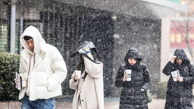 출근길 시민들이 9일 오전 서울 중구 명동 인근에서 눈을 맞으며 걸어가고 있다. 뉴시스