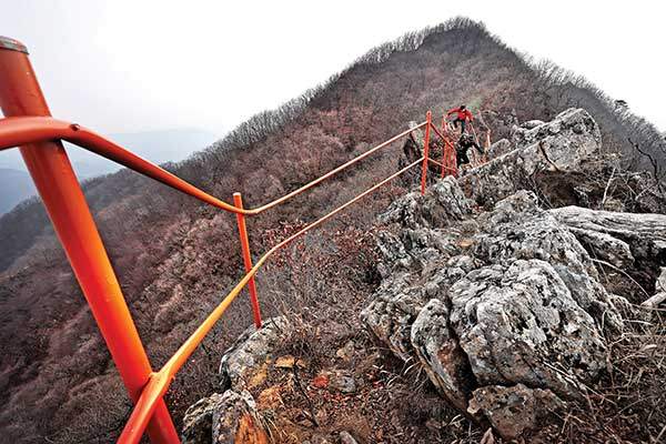 회색빛 암릉 위로 주황색 철난간이 줄지어 박혀 있다.