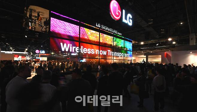 LG전자 CES 2024 부스를 찾은 관람객들이 세계 최초 무선 투명 올레드 TV ‘LG 시그니처 올레드 T’ 15대로 구성된 미디어 아트를 감상하고 있다. (사진=LG전자)