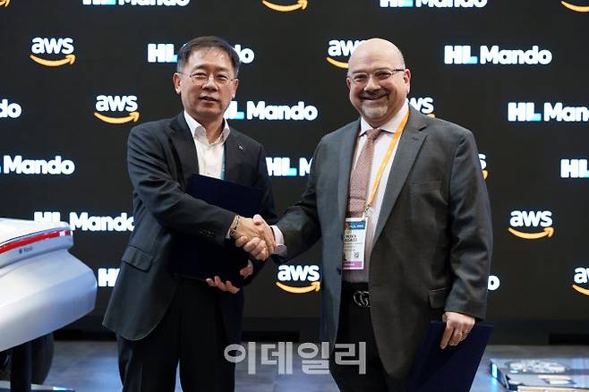 조성현(왼쪽) HL만도 부회장, 야세르 알사이드 AWS IoT 부문 부사장이 지난 9일(현지 시각) CES 2024 ‘HL만도’ 부스에서 모빌리티 소프트웨어 관련 협약을 체결하고 기념촬영을 하고 있다. (사진=HL만도)