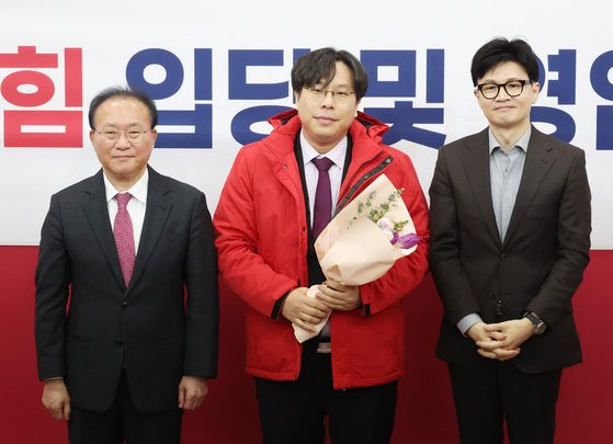 지난 8일 국회에서 열린 국민의힘 입당 및 영입 환영식에서 한동훈 비상대책위원장과 윤재옥 원내대표가 학교폭력 전문 변호사인 박상수 변호사에게 당 점퍼를 입혀주고 기념촬영을 하고 있다. 연합뉴스