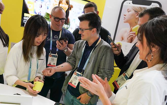 CES 2024에 마련된 LG생활건강의 휴대용 타투 프린터 임프린투 부스에서 외국인 관람객이 임프린투를 체험하고 있다. LG생활건강 제공