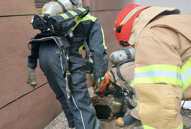 [광주=뉴시스] 광주 북구 용봉동 한 골목길에서 맨홀에 빠진 여성을 구조하는 소방. (사진=광주 북부소방서 제공). photo@newsis.com *재판매 및 DB 금지