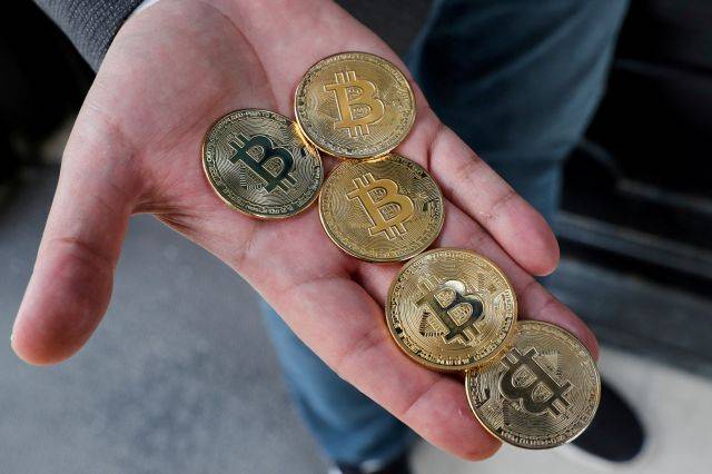 튀르키예 암호화폐 거래소 코인트랄의 공동 설립자인 우구르 하칸 카칸이 2021년 4월 27일(현지시간) 이스탄불에서 비트코인을 형상화한 동전을 손바닥에 올려 보여주고 있다. 로이터연합뉴스