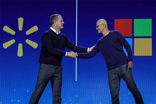 Walmart CEO Doug McMillon (L) greets Microsoft Chairman and CEO Satya Nadella during McMillon’s keynote address during CES 2024 at The Venetian Resort Las Vegas on January 9, 2024 in Las Vegas, Nevada. [Photo by AFP] [Image source: Gettyimagesbank]