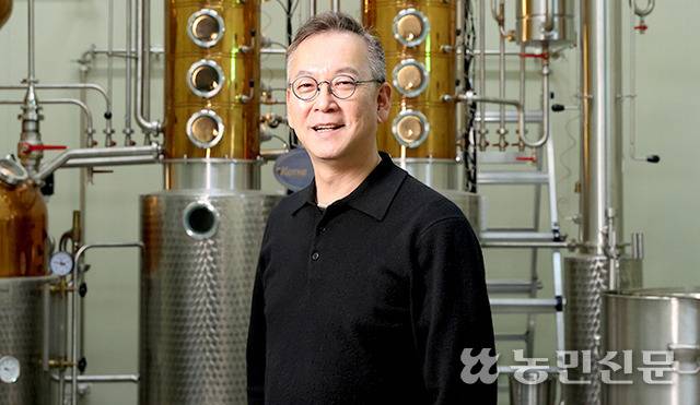 오규섭 대표가 독일산 코테사 증류기 앞에서 활짝 웃고 있다.