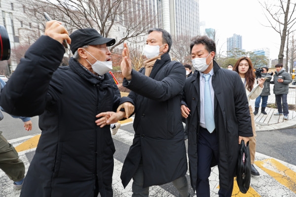 유해 화학물질 원료를 이용해 가습기살균제를 제조·판매한 혐의로 기소된 안용찬(오른쪽) 전 애경산업 대표가 11일 항소심에서 유죄를 선고받고 서울고등법원 앞을 나서던 중 가습기살균제 피해 관계자로부터 항의를 받고 있다. 연합뉴스