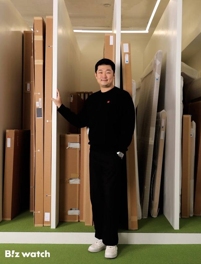 김재욱 열매컴퍼니 대표가 그림 수장고 앞에서 자세를 취하고 있다./사진=비즈워치