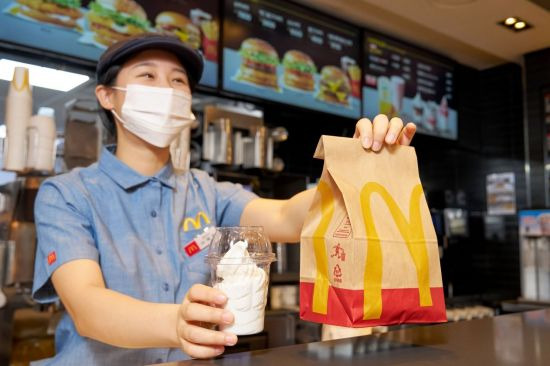 한국맥도날드 매장 직원이 친환경 재생페트(rPET) 컵에 담긴 '선데이 아이스크림'을 고객에게 전달하고 있다.[사진제공=한국맥도날드]