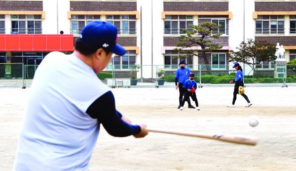 군산 중앙초 야구부 오장용 감독이 수비 연습을 위해 배트로 공을 쳐 주는 ‘펑고’ 훈련을 하는 모습. 오 감독은 선수를 모으기 위해 발로 뛰었지만 인구 감소라는 근본적인 문제를 넘기에는 역부족이었다. 군산=권현구 기자