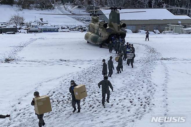 [와지마=AP/뉴시스]일본 자위대가 노토 반도 지진 구호 활동을 위해 파견 인력을 7000명까지 증원하기로 했다. 8일 일본 이시카와현 와지마시에서 자위대 대원들이 눈길을 걸어 지진 피해 지역으로 구호 물품을 나르고 있다. 2024.01.16.