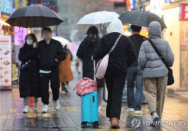 17일 오후부터 18일까지 전국 비·눈…다시 평년보다 포근 (서울=연합뉴스) 서대연 기자 = 비가 내린 지난 14일 서울 중구 명동거리에서 관광객들이 외투 모자를 쓰고 이동하고 있다.