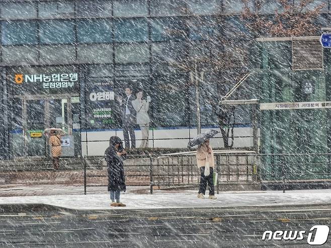 전국 대부분 지역에 눈이 내릴 것으로 예보된 17일 오후 서울 서대문구 서대문역 인근에서 시민들이 함박눈을 맞으며 이동하고 있다. 2024.1.17/뉴스1 ⓒ News1 황덕현 기후환경전문기자