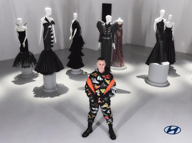 미국 패션 디자이너 제러미 스콧이 지난해 3월 현대차 아이오닉 6의 부품을 소재로 직접 디자인한 ‘업사이클링(Up-cycling)’ 의상 앞에 서있는 모습. 현대차·기아 제공