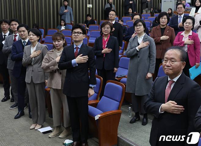 한동훈 국민의힘 비상대책위원장과 윤재옥 원내대표 등이 18일 서울 여의도 국회에서 열린 의원총회에서 국기에 경례를 하고 있다. 2024.1.18/뉴스1 ⓒ News1 송원영 기자