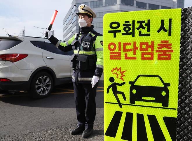 19일 서울 강서구 한 교차로에서 경찰이 우회전 일시정지 계도 및 단속 활동을 벌이고 있다. 연합뉴스