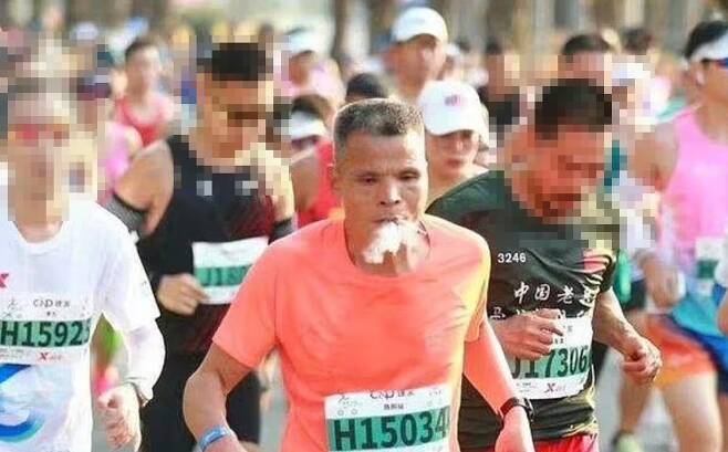 1월 7일 열린 샤먼마라톤 대회에서 첸(52)이 담배를 피우며 뛰고 있다. / 사진= 데일리메일