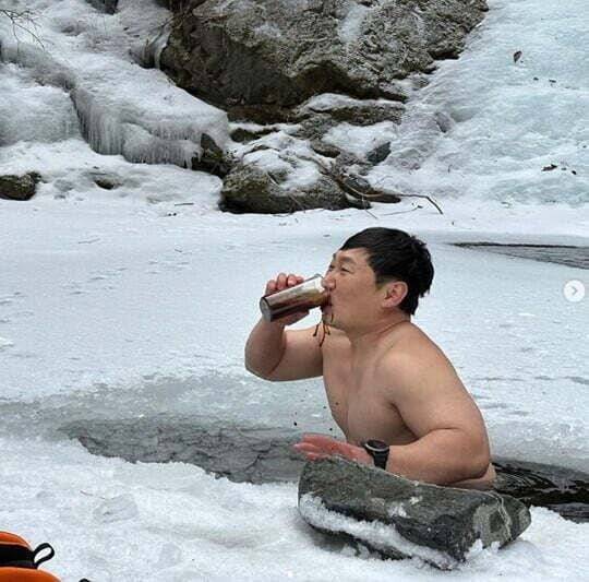 '얼죽아'가 10~30대 젊은이들을 묶어주는 문화 현상이 되면서, 이를 실천하는 연예인들의 인증샷이 겨울마다 올라온다. 개그맨 이승윤이 산속 얼음 호수를 깨고 들어가서 아이스 아메리카노를 마시는 모습. /인터넷 커뮤니티