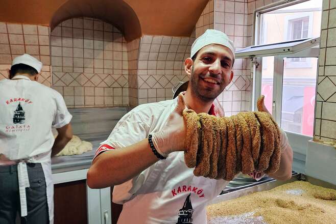 이스탄불 빵집 ‘갈라타 시미트치시’ 제빵사가 뽕 당밀과 참깨를 묻힌 시미트 반죽을 들어 보이고 있다./김성윤 기자