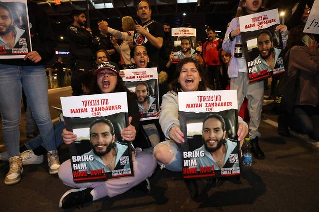 20일(현지시간) 이스라엘 텔아비브에서 열린 시위에서 인질 가족들과 지지자들이 가자지구에 억류된 이스라엘 인질들의 사진이 담긴 손팻말을 들고 인질 석방을 촉구하고 있다.(사진=AFP)