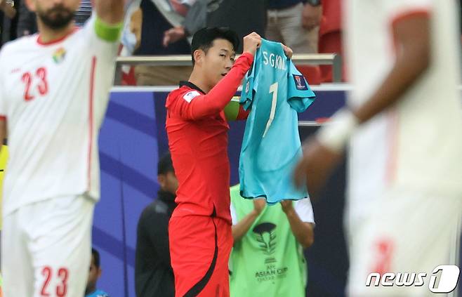 대한민국 축구대표팀 손흥민이 20일(현지시간) 카타르 도하 알투마마 스타디움에서 열린 2023 아시아축구연맹(AFC) 카타르 아시안컵 조별리그 E조 조별리그 2차전 요르단과 대한민국의 경기에서 페널티킥을 넣은 후 부상으로 소집해제 된 김승규의 유니폼을 들고 있다. 2024.1.20/뉴스1 ⓒ News1 김성진 기자