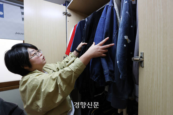 황인후씨가 자택에서 경향신문과 인터뷰하며 자신의 옷장을 살펴보고 있다. 조태형 기자