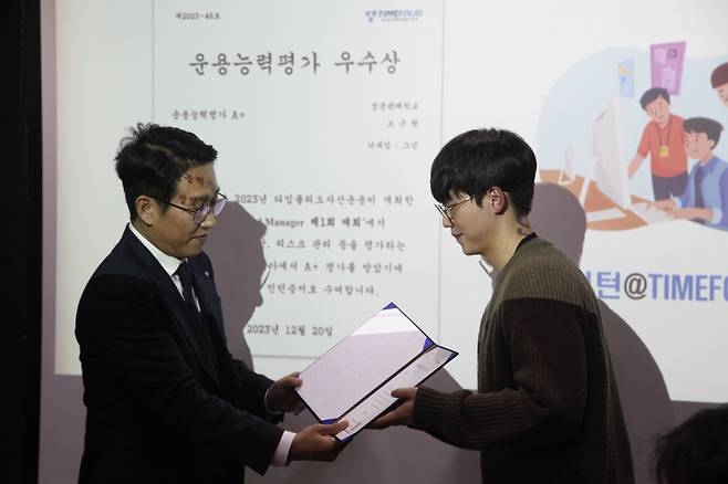 2023년 12월 20일 서울 여의도 타임폴리오자산운용 본사에서 열린 제1회 ‘로드 투 펀드매니저’ 투자대회 시상식에서 전체 1위를 차지한 조근원 군(성균관대)이 황성환 타임폴리오자산운용 대표로부터 상장을 받고 있다. / 전준범 기자
