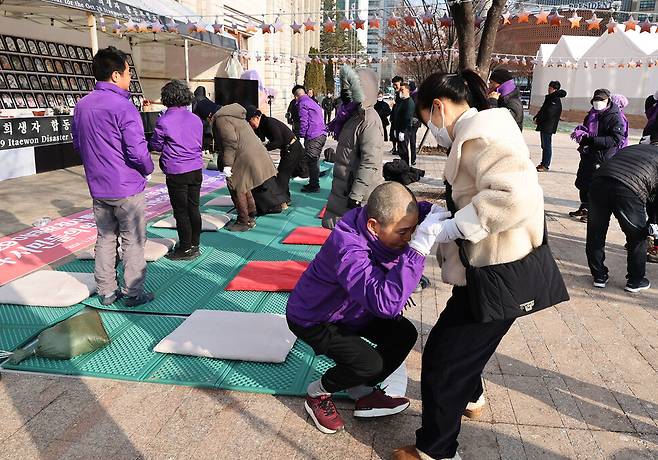 이태원 참사 희생자인 고 이남훈씨의 어머니 박영수씨가 이태원 참사 특별법 공포 촉구 1만5900배 철야 행동 중 200배를 마친 뒤 다리에 힘이 풀려 다른 사람의 도움을 받아 일어나고 있다. 백소아 기자