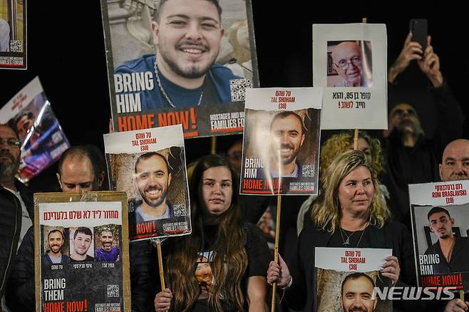 [텔아비브=AP/뉴시스] 지난 12월30일 이스라엘 텔아비브에서 인질 석방 요구 집회가 열려 하마스에 억류된 인질들의 가족과 지지자들이 인질들의 사진을 들고 있다. 시위대는 전쟁 중단도 촉구하면서 전쟁을 고수하고 있는 베냐민 네타냐후 총리의 조기 퇴진과 조기 총선을 요구했다.  2023.01.22.