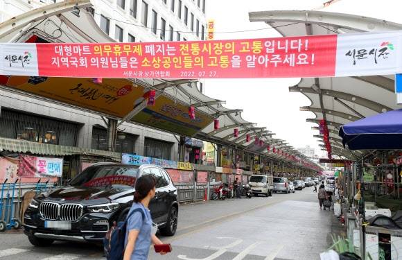 2022년 8월 대구 최대 전통시장인 서문시장 관문에 ‘대형마트 의무휴무제 폐지는 전통시장의 고통입니다!’ 등의 내용이 담긴 현수막이 걸려 있다. 연합뉴스