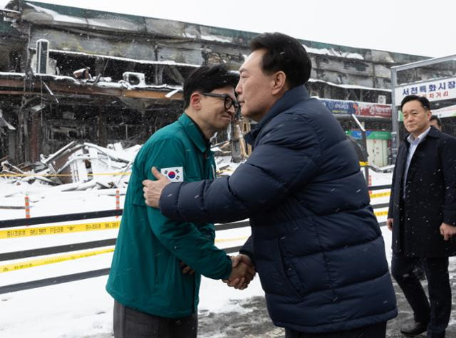 윤석열 대통령이 23일 오후 충남 서천군 서천수산물특화시장 화재 현장을 찾아 피해 상황을 점검하기 앞서 한동훈 국민의힘 비상대책위원장을 만나 악수하고 있다. 대통령실 제공