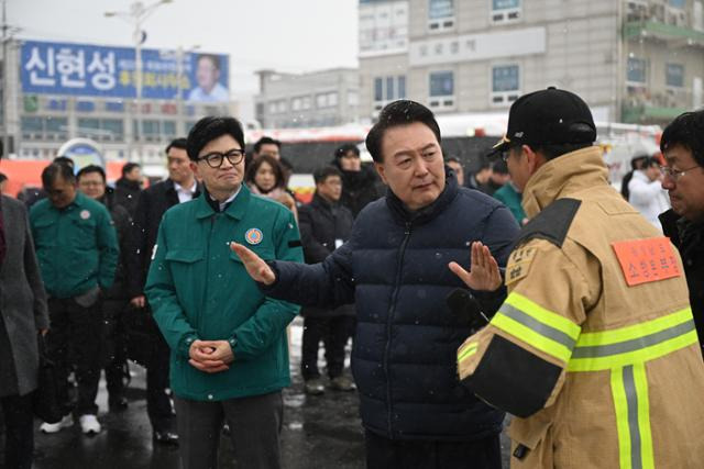 윤석열 대통령이 23일 충남 서천군 서천읍 서천 특화시장 화재 현장을 방문해 한동훈 국민의힘 비상대책위원장과 함께 권혁민 충남 소방본부장으로부터 피해상황을 보고 받고 있다. 대통령실 제공