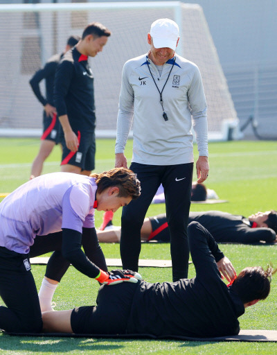 위르겐 클린스만 축구대표팀 감독(가운데)이 23일 카타르 도하 알에글라 훈련장에서 조현우(왼쪽)의 도움을 받아 스트레칭으로 몸을 푸는 이강인을 살펴보고 있다. 도하 | 연합뉴스