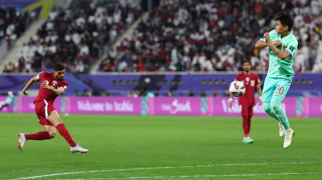 카타르 하산 알 하이도스의 발리슛을 막기 위해 점프하는 중국 웨이스하오