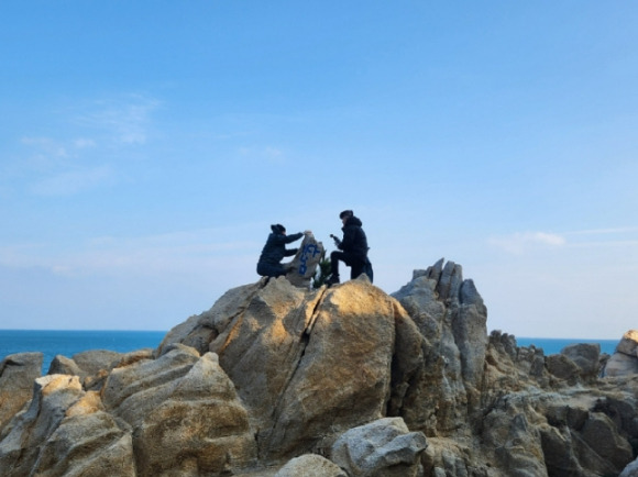 울산 대왕암공원 기암괴석에 파란 페인트로 '바다남'이라는 낙서를 남긴 여성이 붙잡혔다. 사진은 울산 동구청 공무원들이 낙서로 훼손된 암석을 정비하고 있는 모습. [사진=울산 동구청]