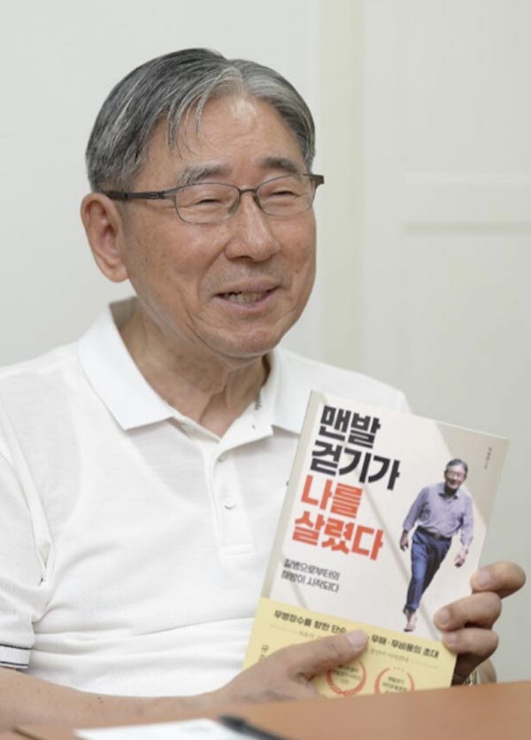 박동창 회장이 놀라운 체험을 소재로 쓴 ‘맨발걷기가 나를 살렸다’ 책을 들고 맨발걷기의 효능을 설명하고 있다.